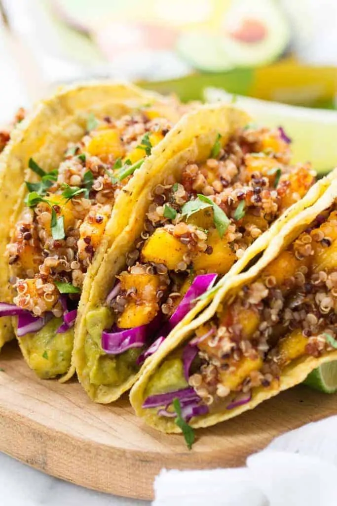 These simple Quinoa Tacos are made with a spicy mango-lime filling and use a creamy guacamole spread on the bottom!