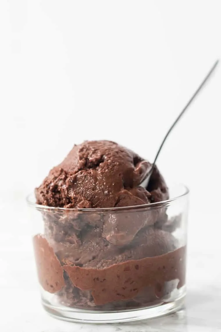 Chocolate cherry banana ice cream in glass bowl with spoon