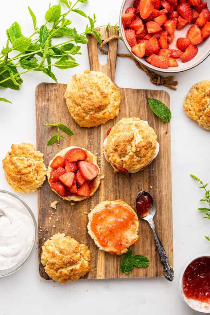 Overhead view of gluten-free vegan strawberry shortcakes being assembled on wooden board
