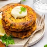 Sweet potato salmon cakes stacked on plate with aioli on top