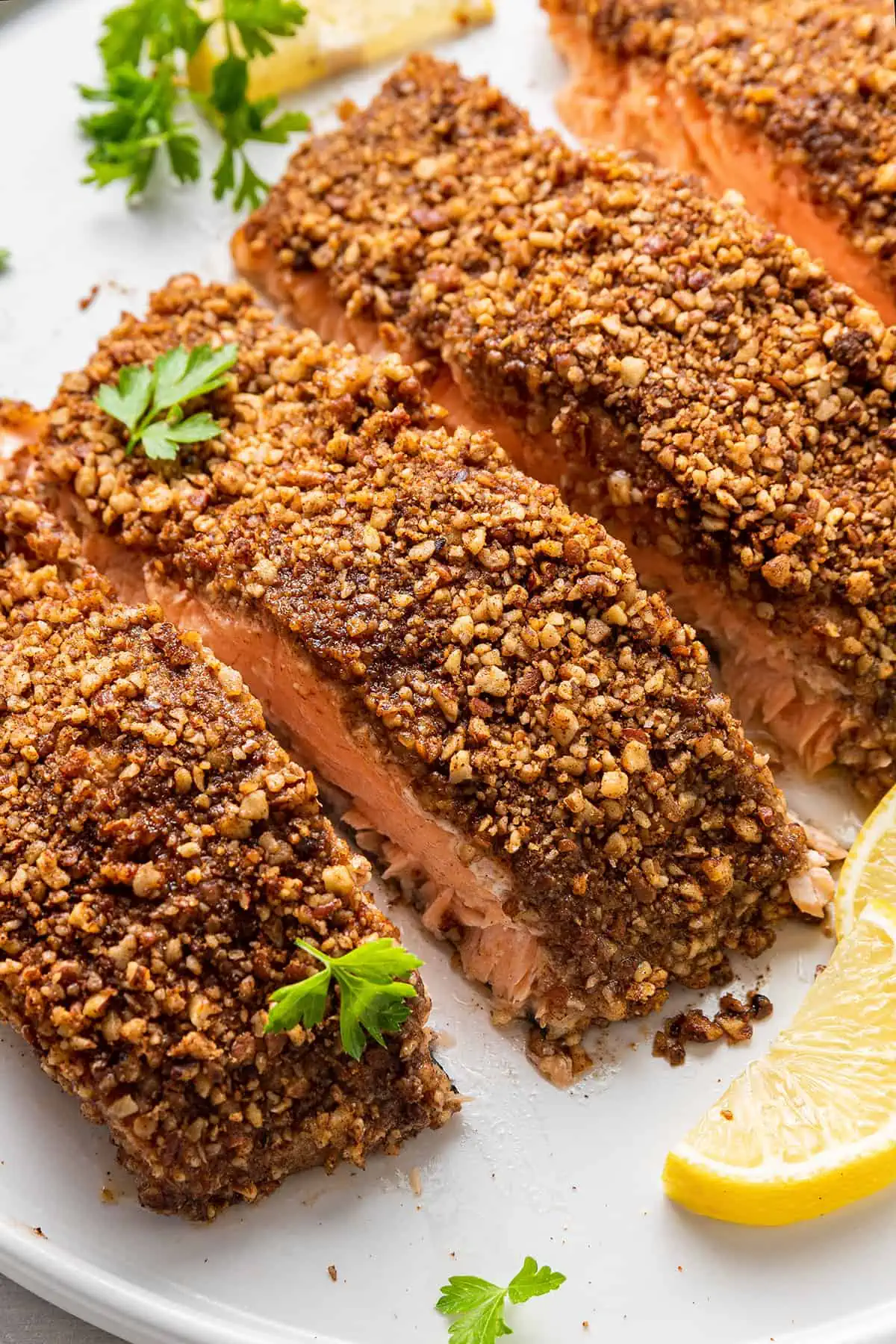A quick and easy pecan crusted salmon recipe full of cozy, wintry spice! With flaky baked salmon smothered in Dijon mustard and crunchy nuts. Four cooked salmon fillets crusted in pecans.