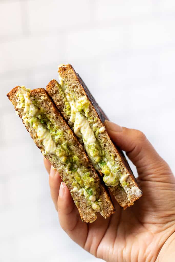 I'll show you how to make a classic vegan grilled cheese, plus easy variations including tomato pesto, broccoli, mushroom, avocado, and more! A hand holding up an avocado grilled cheese.