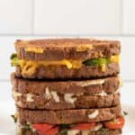 Assorted grilled cheese variations stacked on a plate.