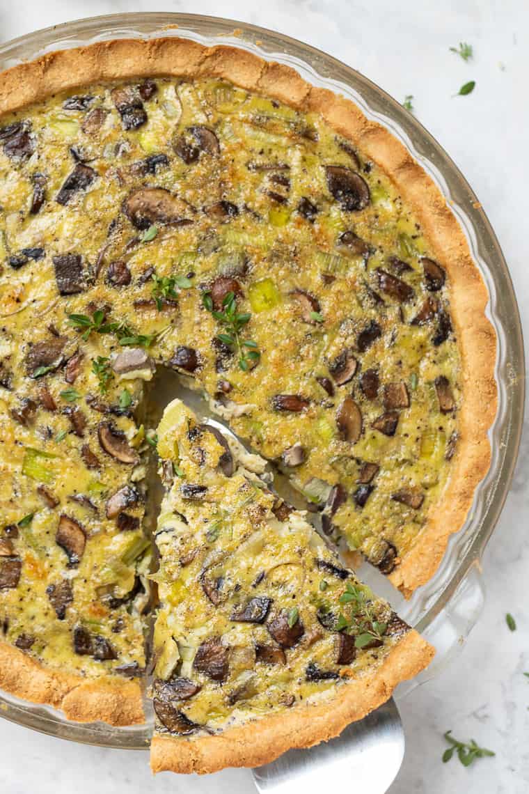 Slice of mushroom quiche being pulled out of pan