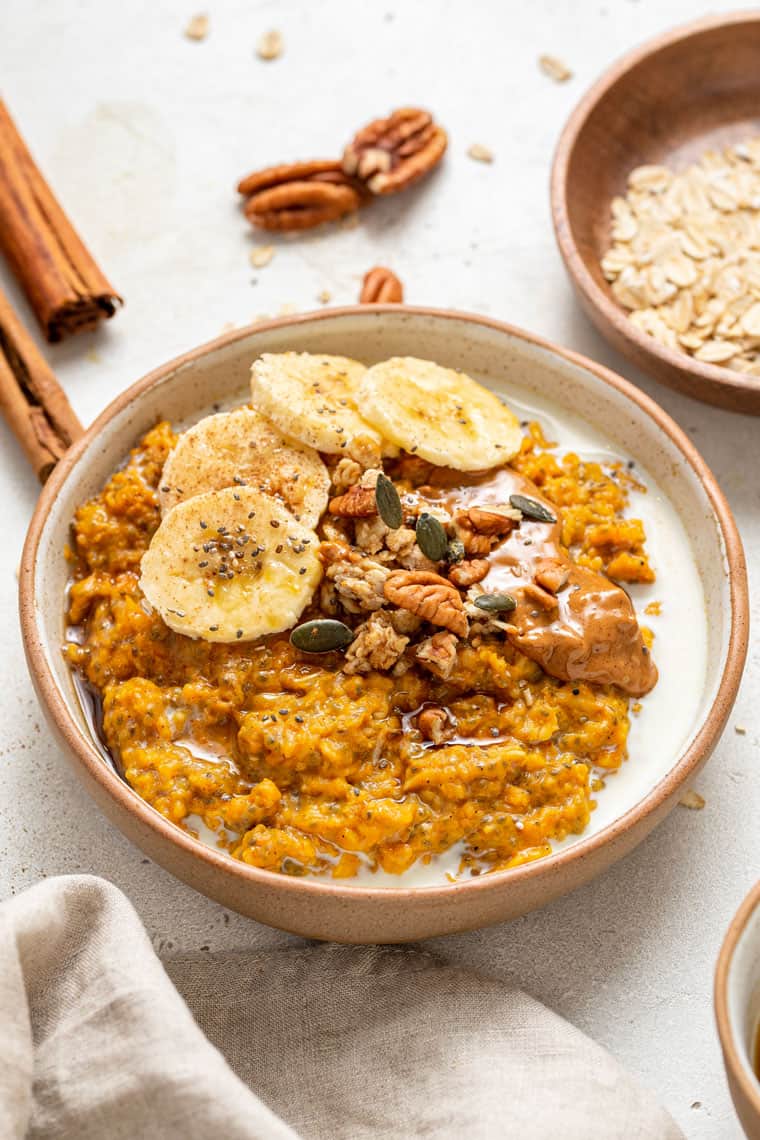 This Pumpkin Oatmeal is a 5-minute vegan gluten-free breakfast with chia seeds and coconut milk. A satisfying and cozy way to start the day! bowl of pumpkin oatmeal with banana