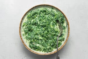 bowl of creamed spinach with a spoon