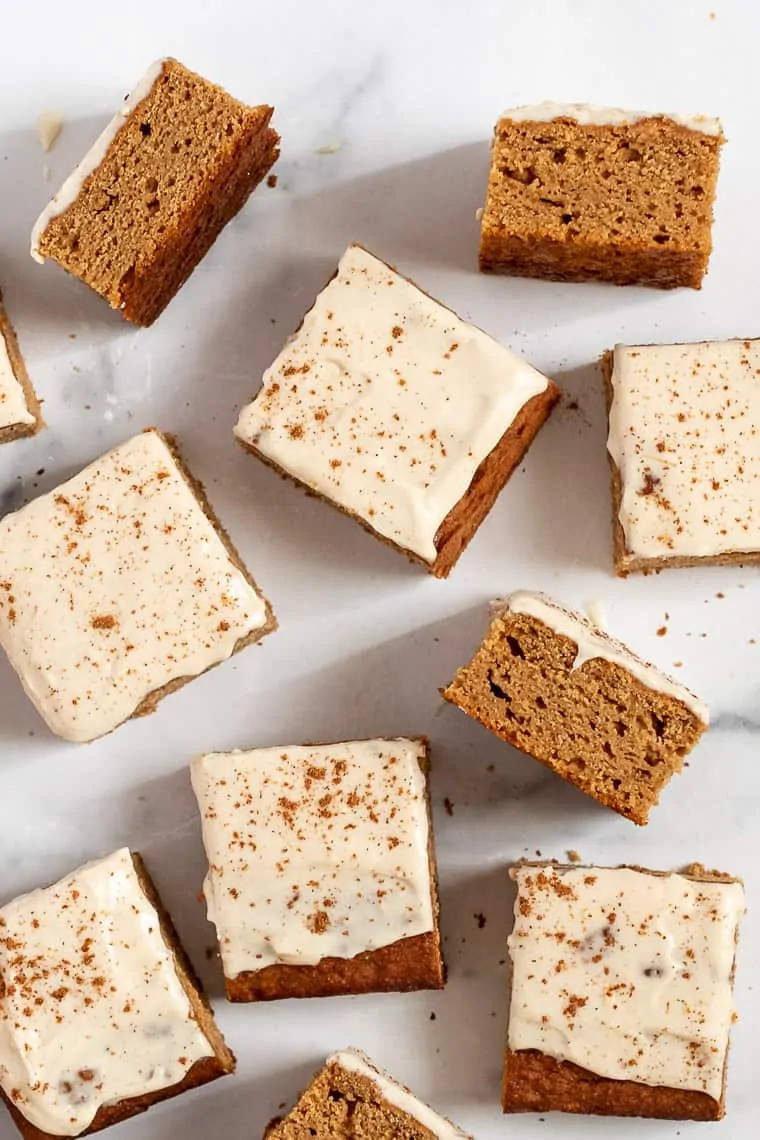 Overhead view of assorted squares of frosted gluten-free apple cake.