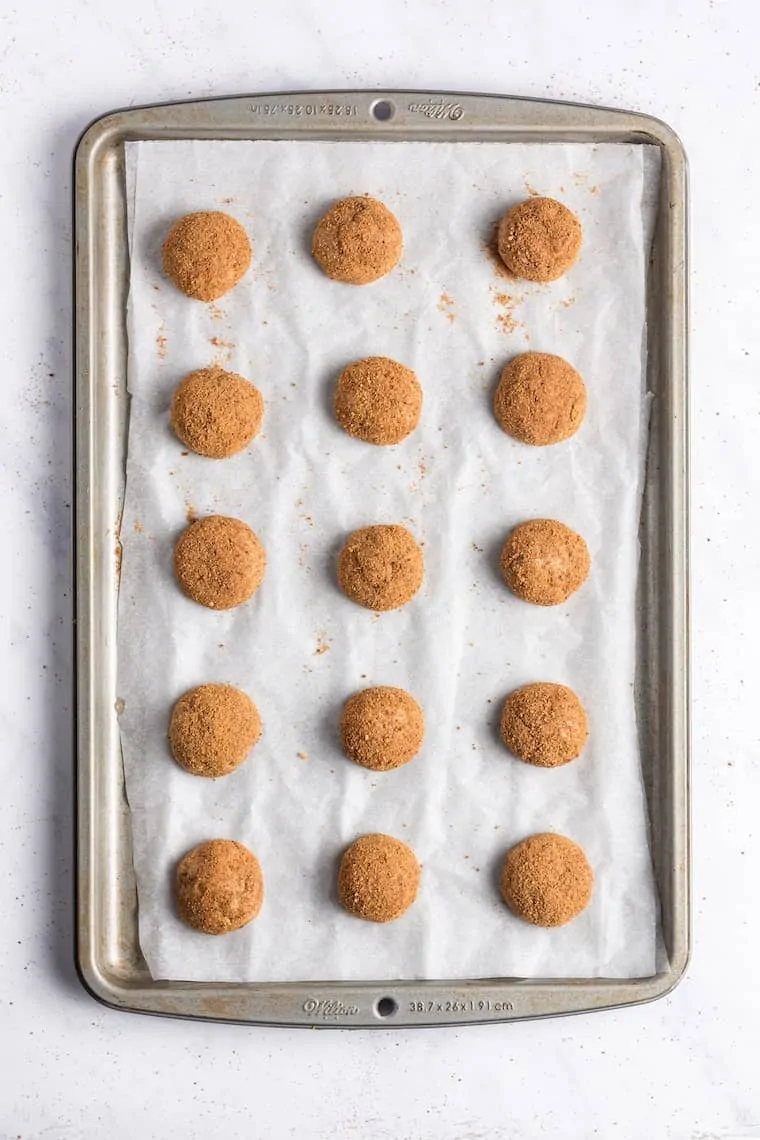 Vegan snickerdoodle cookies on parchment-lined baking sheet