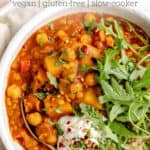 close up on a bowl of slow cooker chickpea soup with coconut yogurt, arugula and quinoa on top