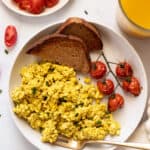 overhead of a white plate with basic tofu scramble with roasted tomatoes and two slices of wheat toast