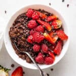 overhead of a white bowl with chocolate oatmeal and fresh berries