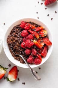 overhead of a white bowl with chocolate oatmeal and fresh berries