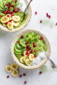 overhead of two bowls with green matcha oatmeal with fresh fruit on top