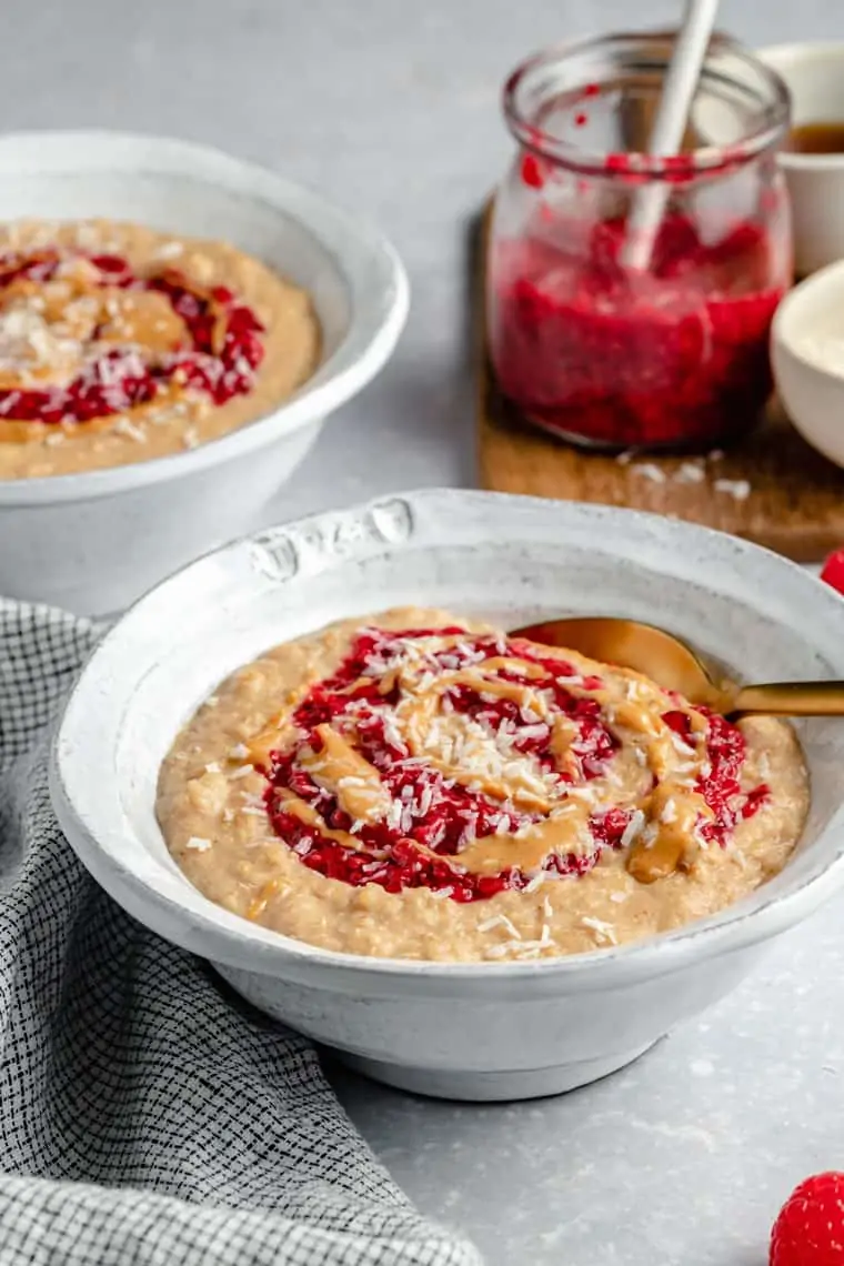 side view of a bowl of peanut butter and jelly oatmeal topped with coconut