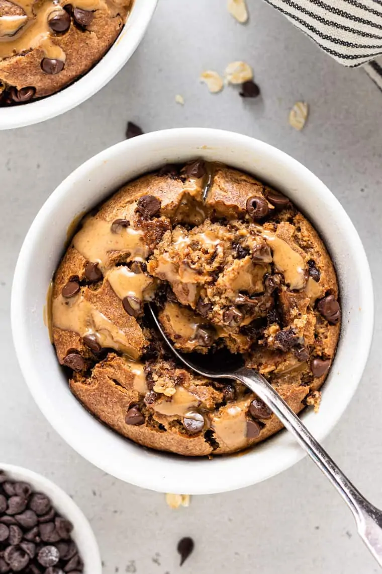 overhead on a white bowl with vegan baked oatmeal with silver spoon and inside bite