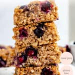 stack of blueberry quinoa breakfast bars on a cutting board with fresh blueberries