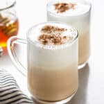 side view of two glass mugs of london fog lattes topped with cinnamon