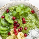 overhead of a bowl with green coconut matcha oatmeal topped with kiwis, grapes, bananas and pomegranate seeds