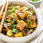 overhead of a white bowl with crispy tofu egg roll topped with sesame seeds