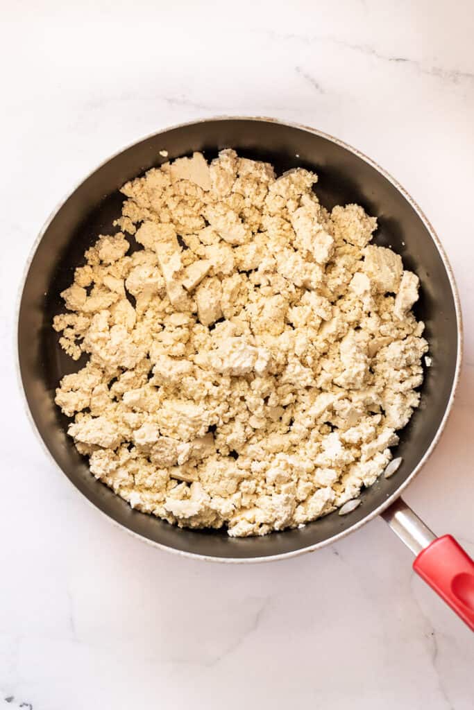 This 10-minute tofu scramble recipe is a satisfying plant-based breakfast with nutritional yeast, turmeric, and garlic for spice and flavor. Crumbled tofu in a large skillet.