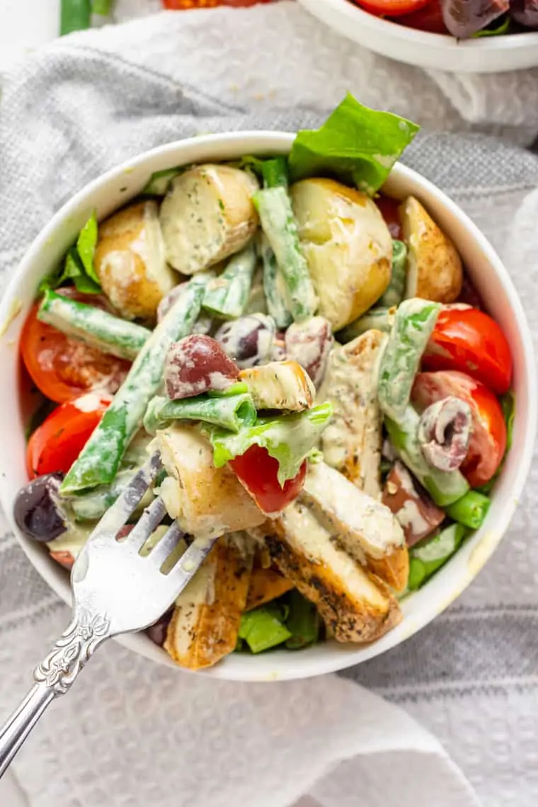 close up overhead of a bowl of tofu nicoise salad with potatoes and green beans