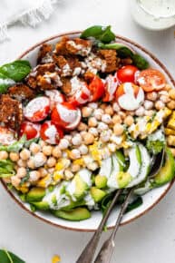 overhead of a bowl with layered vegan cobb salad and creamy dressing