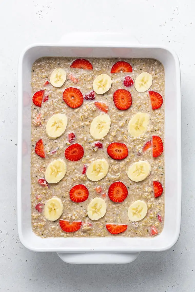 overhead of a baking dish with uncooked strawberry banana baked oatmeal