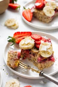 close up on a square of strawberry baked oats topped with fresh fruit