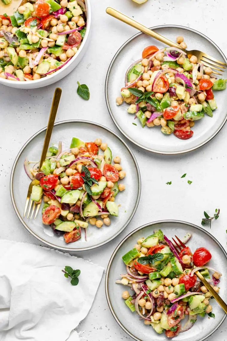 three plate filled with chickpea and vegetable salad