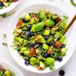 overhead of a white bowl with quinoa blueberry power salad with dressing
