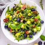 white bowl of blueberry, pecan, quinoa and arugula salad