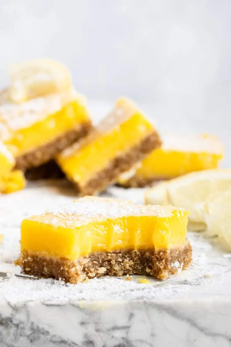 bitten-into dairy-free lemon bar with almond crust