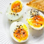 three soft boiled eggs on a plate with corners of toast