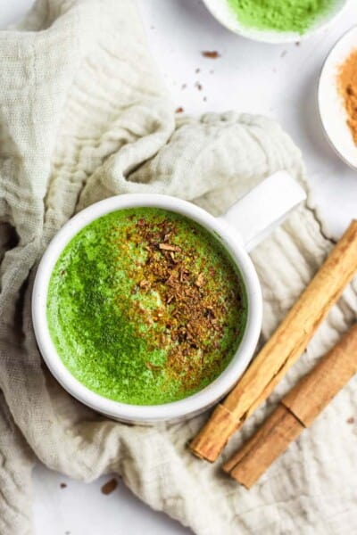mug of green matcha latte on a cozy blanket