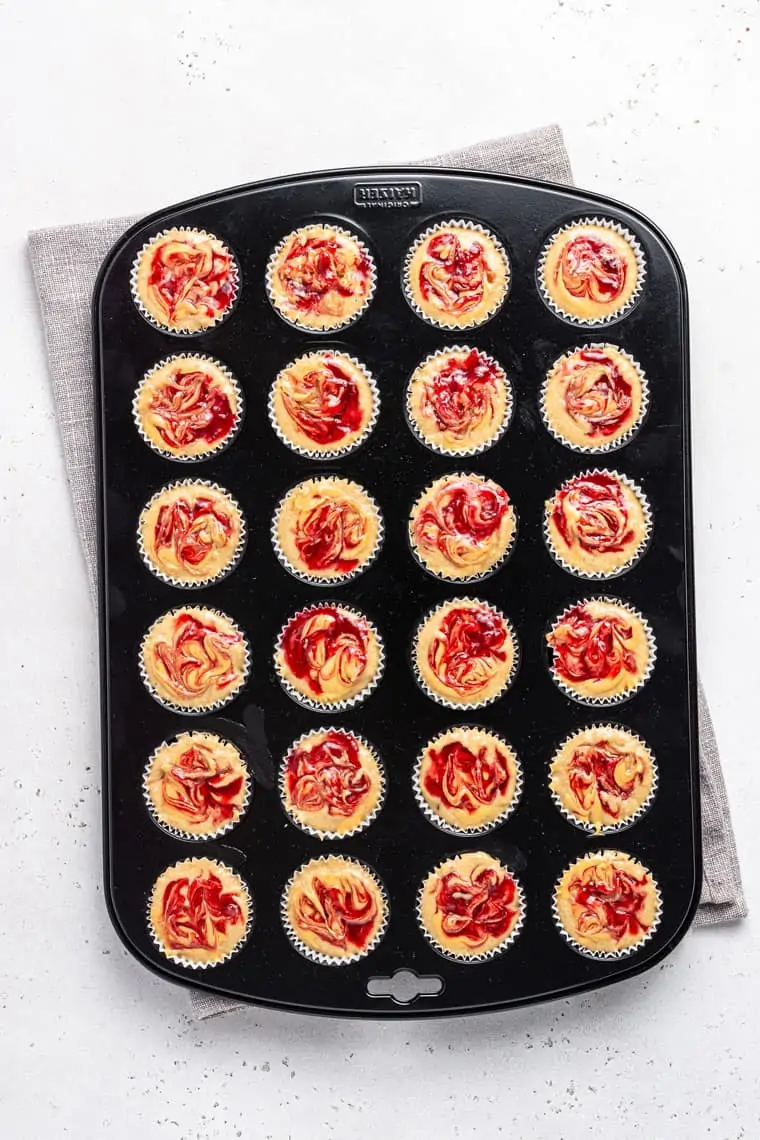overhead of mini peanut butter and jelly muffins in a mini muffin tin before baking