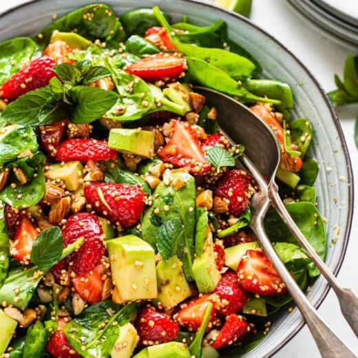 bowl of strawberry spinach avocado salad with dressing