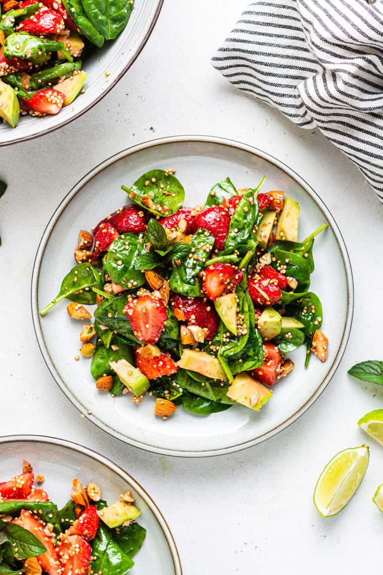 overhead of strawberry spinach salad with avocado