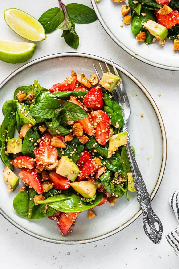 close up on a plate of strawberry spinach and quinoa salad