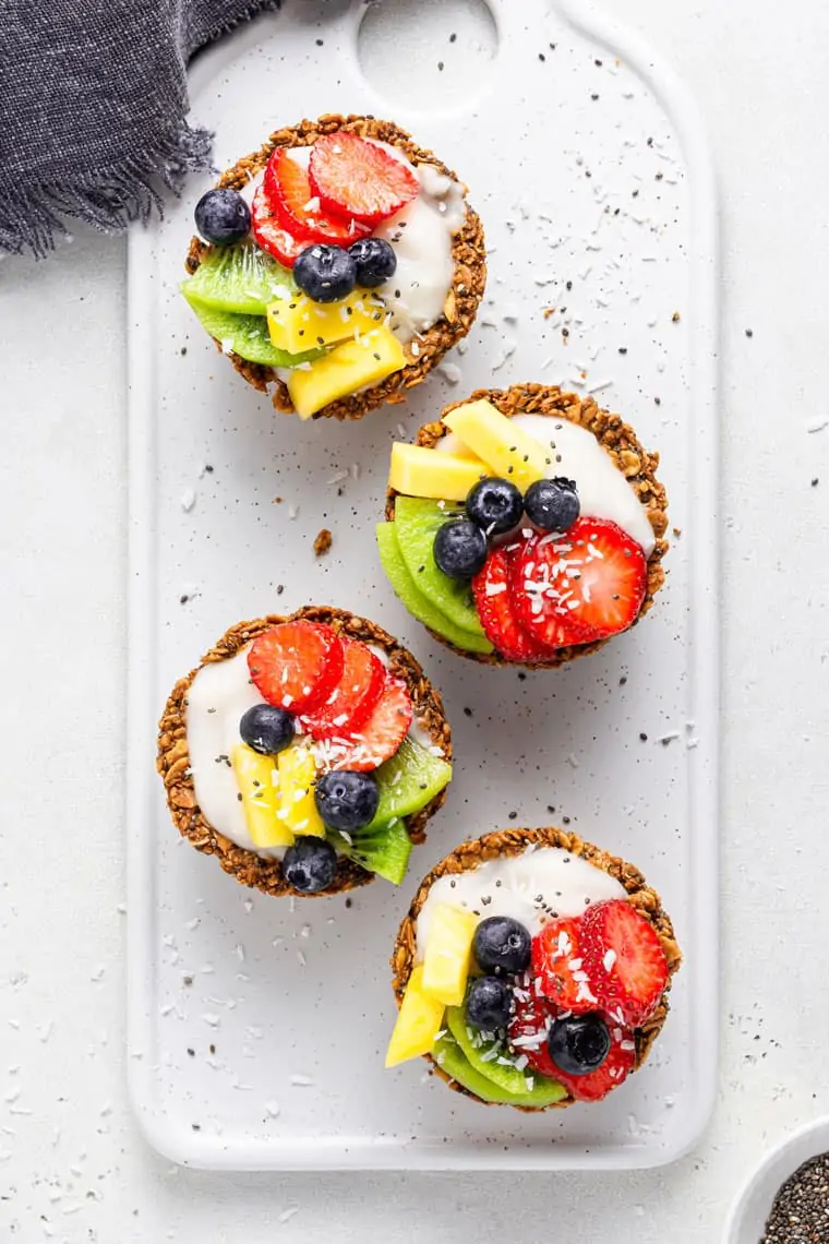 overhead of a tray with four oatmeal cups filled with fruit