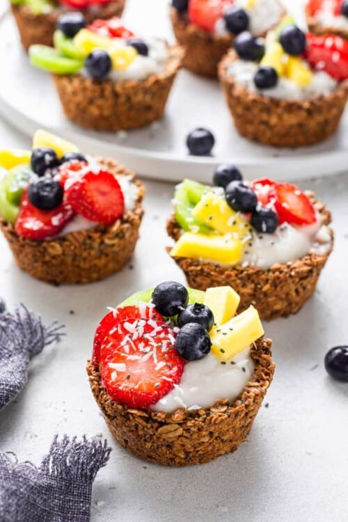 three oatmeal cups filled with yogurt and fruit