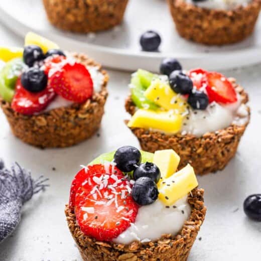 three oatmeal cups filled with yogurt and fruit