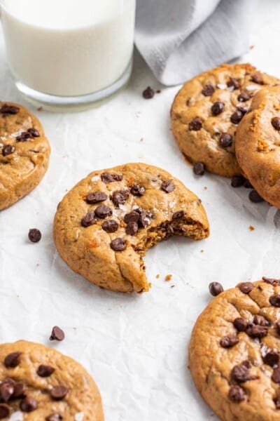 almond butter cookie with chocoalte with a bite taken out on a white background