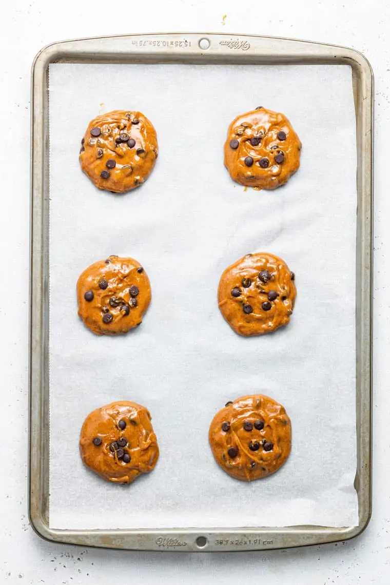 baking sheet with six raw chocolate chip cookies