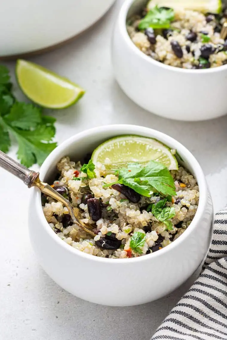 close up on a white bowl with cilantro lime quinoa and bean salad