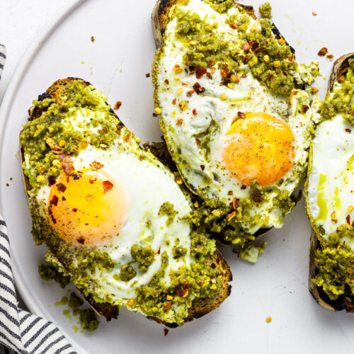 close up on toast topped with pesto and fried eggs