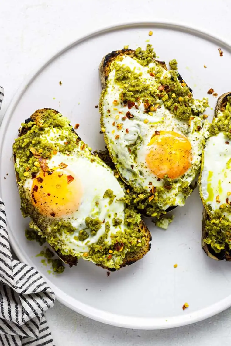 close up on toast topped with pesto and fried eggs