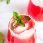 two glasses with fresh watermelon margarita on ice with mint
