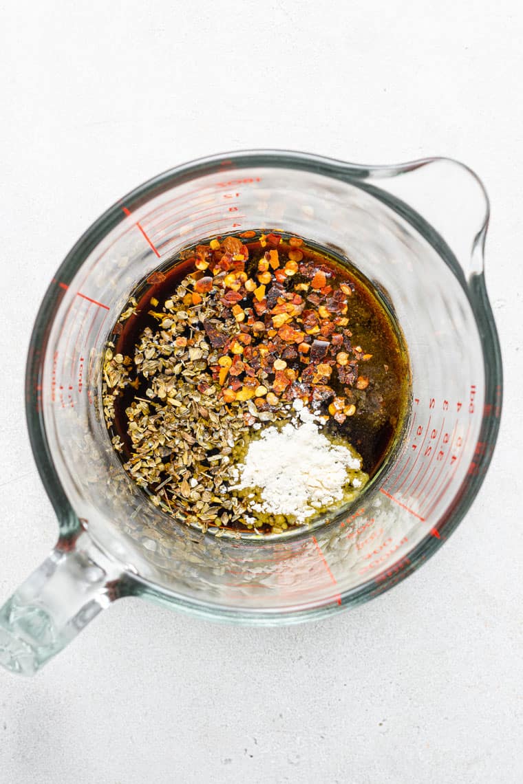 overhead of a glass measuring cup with balsamic marinade ingredients