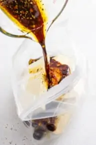 pouring marinade into a bag of tofu pieces