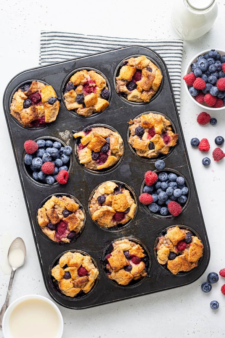 muffin pan filled with baked french toast and fresh berries